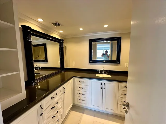 a bathroom with a granite countertop sink a mirror and a shower