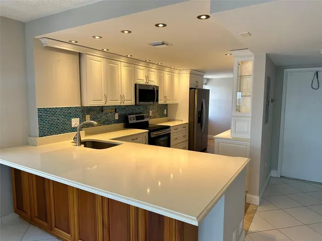 a kitchen with stainless steel appliances granite countertop a refrigerator and a stove