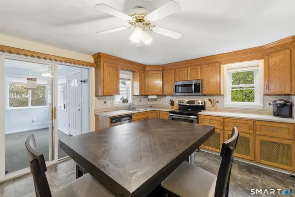 a kitchen with a table chairs microwave and cabinets