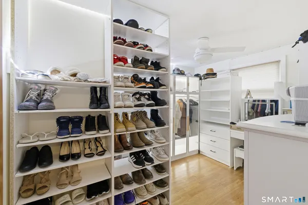 a view of walk in closet with clothes and shoes