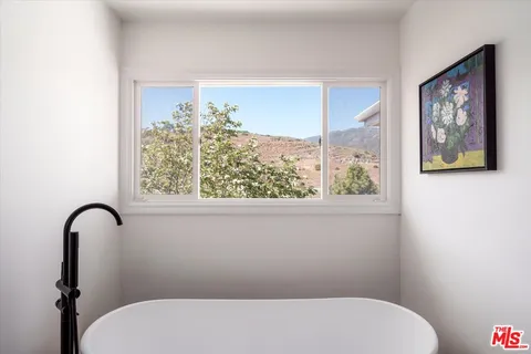 a bathroom with a toilet and a large window