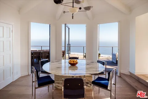 a view of a dining room with a table and chairs