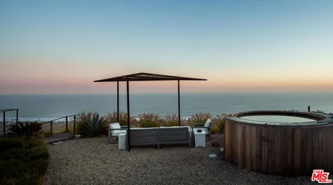 a view of a balcony with chairs and wooden floor