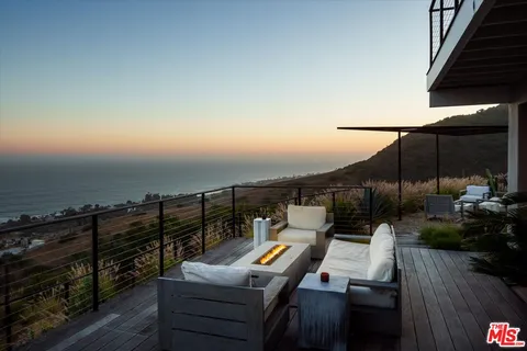 a balcony with outdoor seating and city view