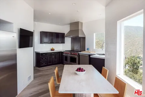 a kitchen with granite countertop a refrigerator stove and sink