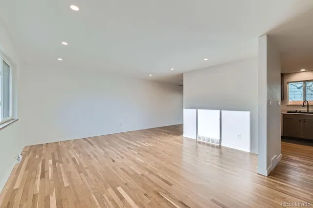 a view of empty room with wooden floor