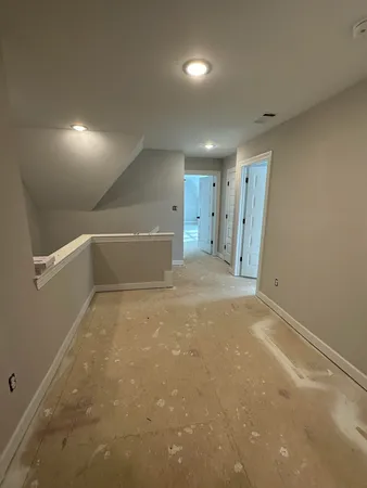 an empty room with windows and ceiling fan