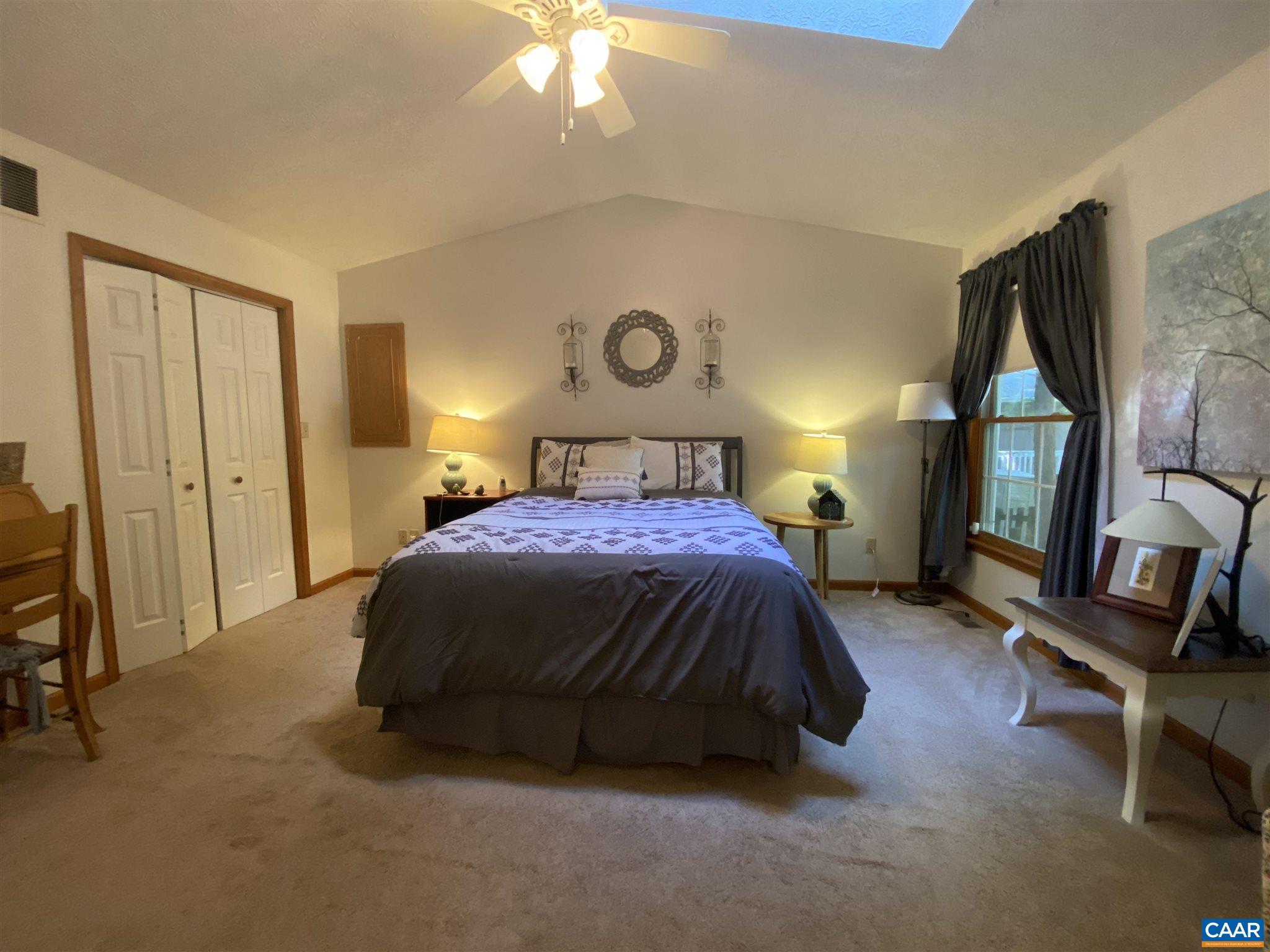 11 Stonefield Road Palmyra, VA 22963 - Photo 15 of 27 a spacious bedroom with a bed and a chandelier