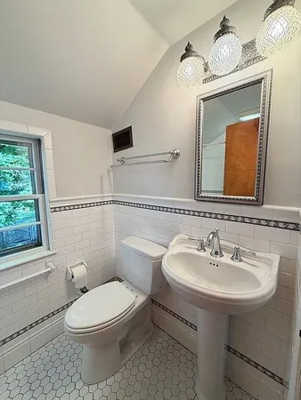 a bathroom with a toilet a sink and a mirror