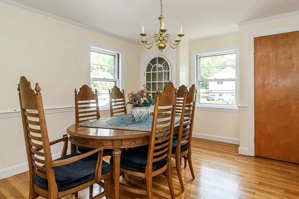 a dining room with furniture a chandelier and wooden floor