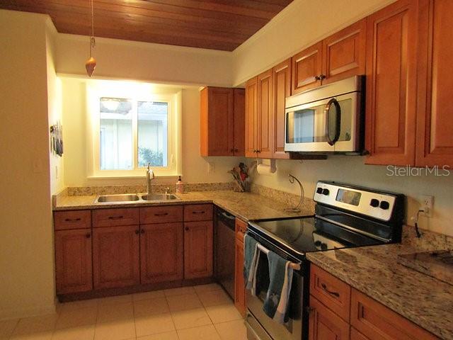 421 Riviera Street Venice, FL 34285 - Photo 5 of 30 a kitchen with stainless steel appliances granite countertop a sink stove and microwave