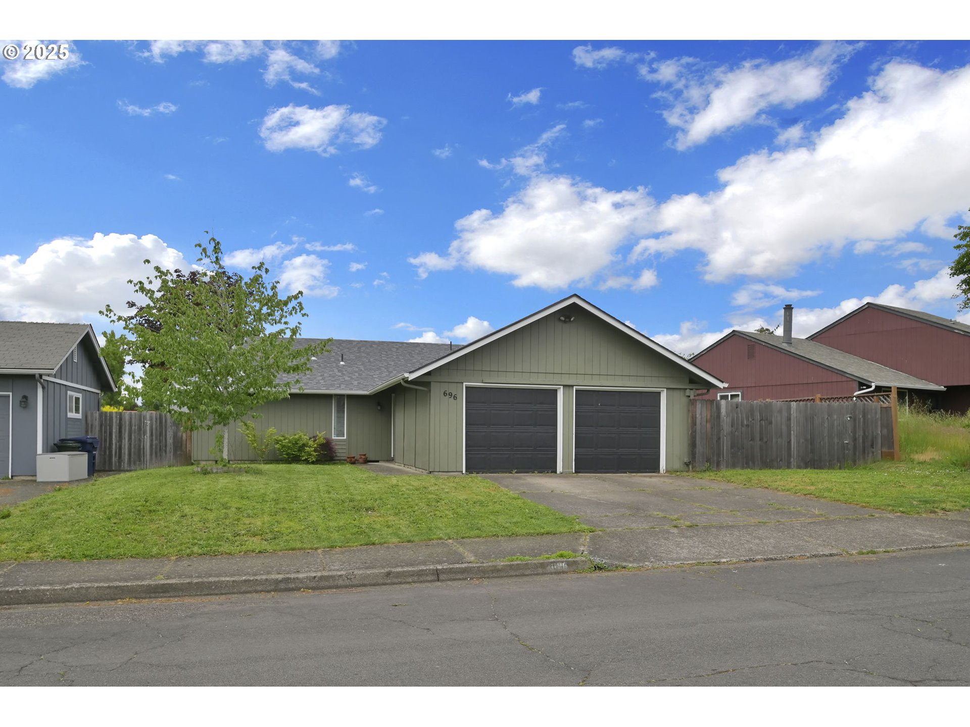 696 Island Street Springfield, OR 97477 - Photo 1 of 27 a view of a yard in front of a house with a large tree