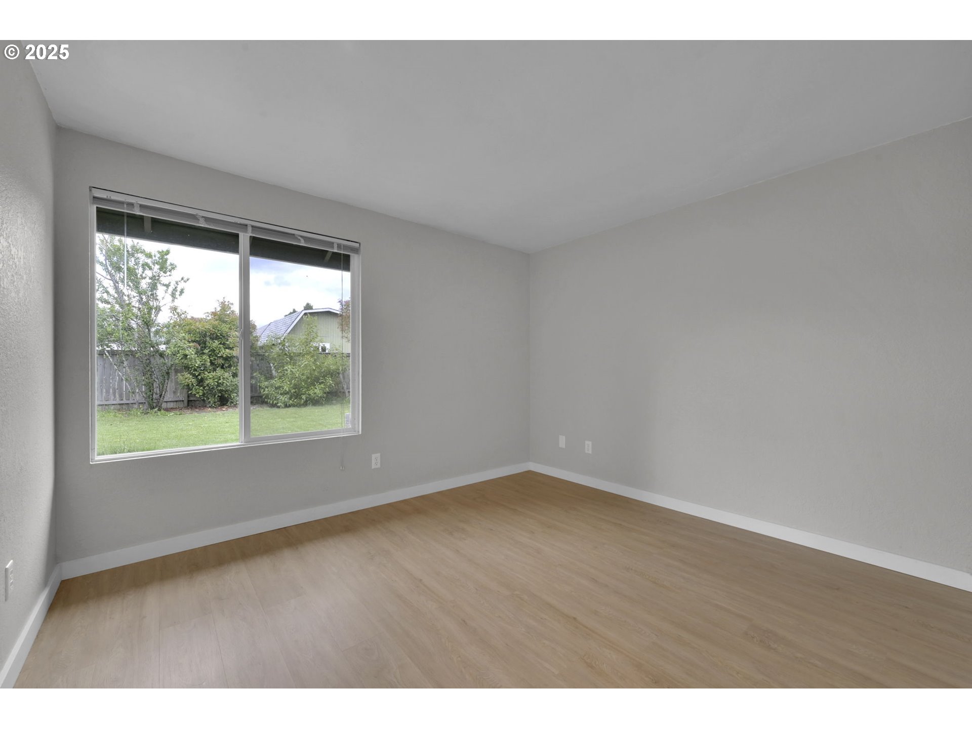 696 Island Street Springfield, OR 97477 - Photo 18 of 27 a view of an empty room with wooden floor and a window