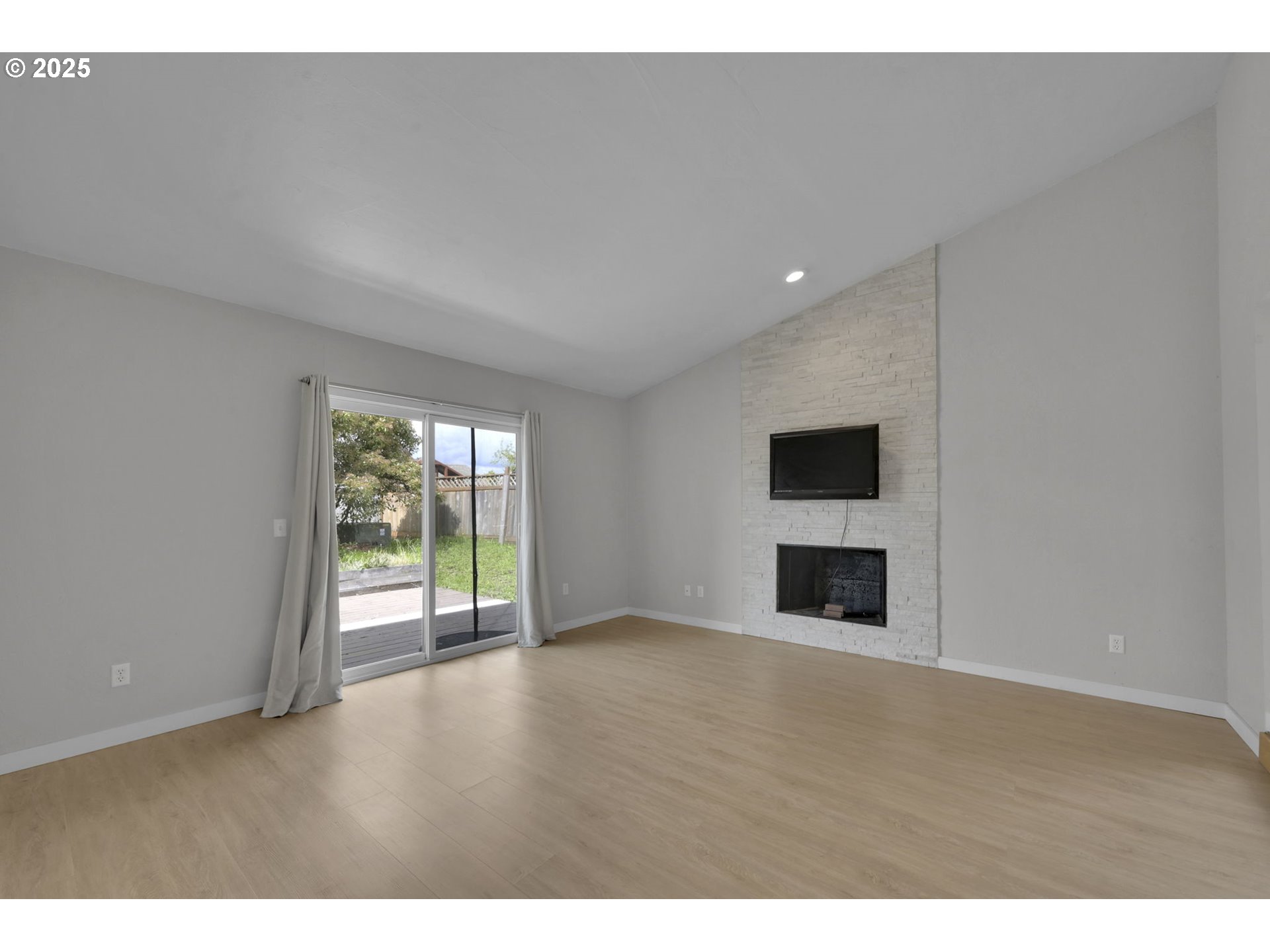 696 Island Street Springfield, OR 97477 - Photo 3 of 27 a view of an empty room with a window and wooden floor