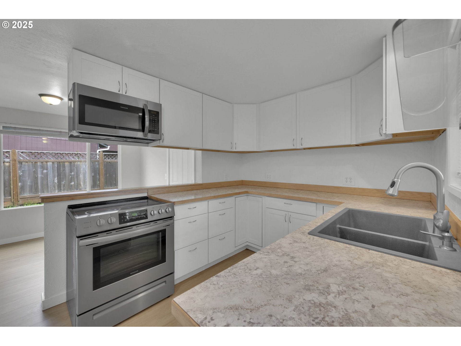 696 Island Street Springfield, OR 97477 - Photo 7 of 27 a kitchen with granite countertop a stove sink and microwave