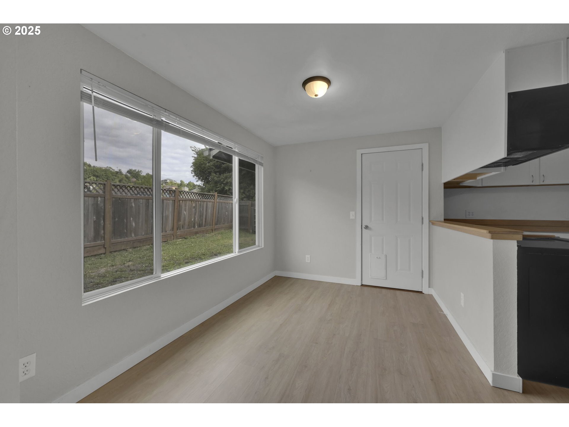 696 Island Street Springfield, OR 97477 - Photo 10 of 27 a view of an empty room with wooden floor and a window