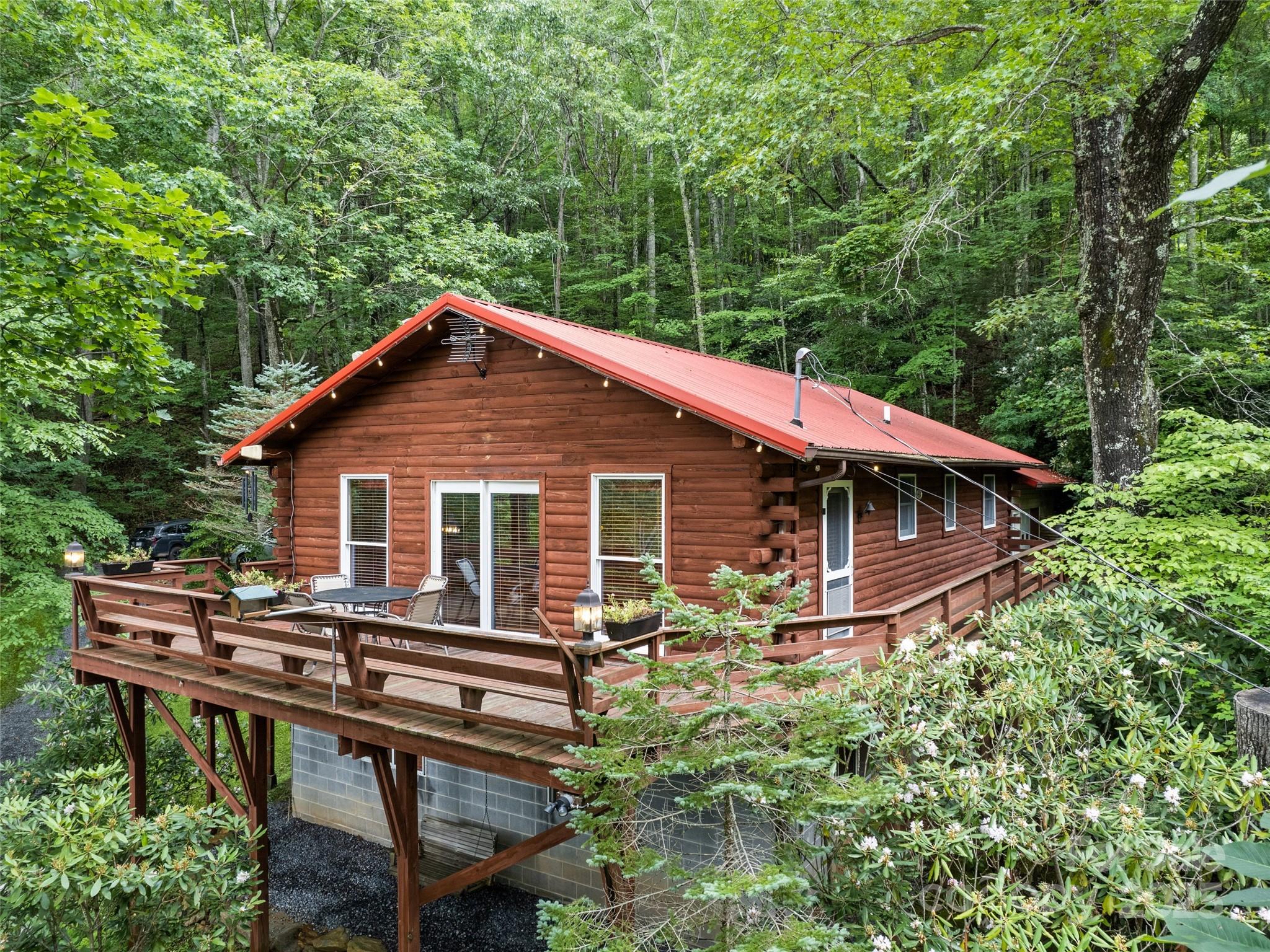 4231 Bald Creek Road Clyde, NC 28721 - Photo 21 of 23 a backyard of a house with table and chairs wooden floor and fence