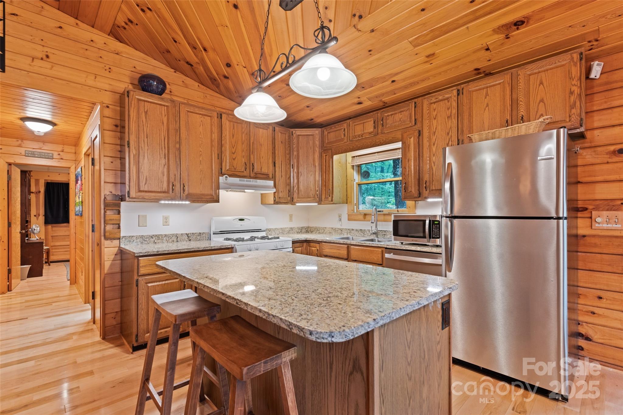 4231 Bald Creek Road Clyde, NC 28721 - Photo 6 of 23 a kitchen with stainless steel appliances granite countertop a sink a refrigerator and wooden cabinets