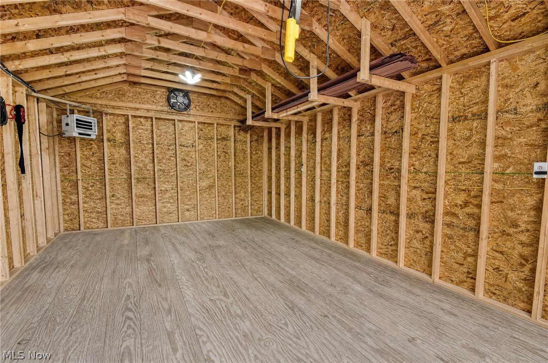 3864 State Road South Ashtabula, OH 44004 - Photo 38 of 50 Exposed wood framing, wood-finish flooring, attached wall heater, ceiling-mounted fan, and integrated ceiling lighting