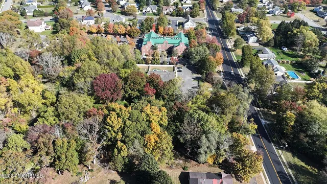an aerial view of residential house with outdoor space and trees all around