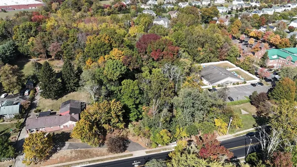 an aerial view of residential house with outdoor space and trees all around