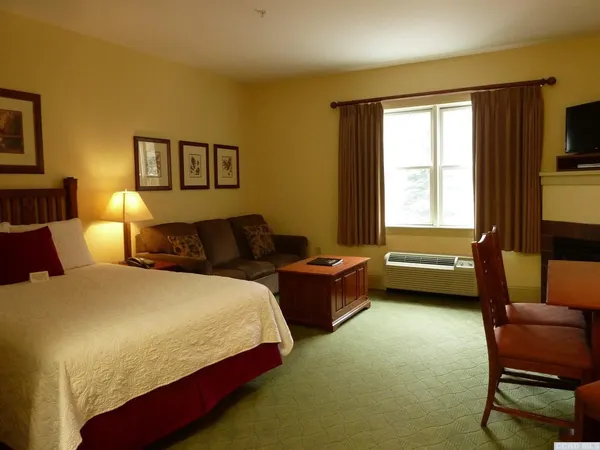 a bedroom with a bed chair and a window