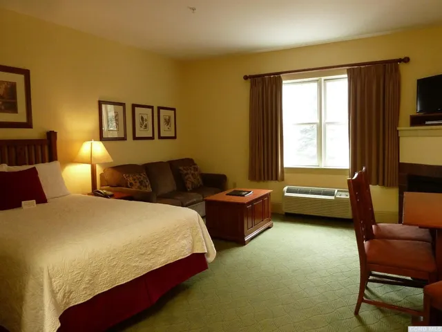 a bedroom with a bed chair and a window