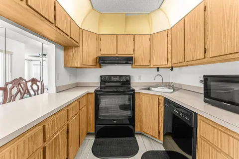 a kitchen with stainless steel appliances granite countertop a sink a stove and cabinets