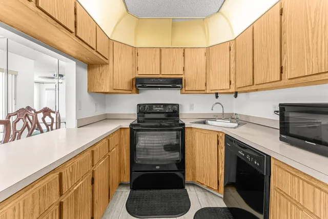 a kitchen with stainless steel appliances granite countertop a sink a stove and cabinets