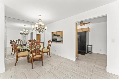 a dining room with chandelier and glass door