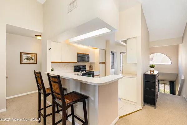 a kitchen with stainless steel appliances kitchen island granite countertop a table chairs and a refrigerator