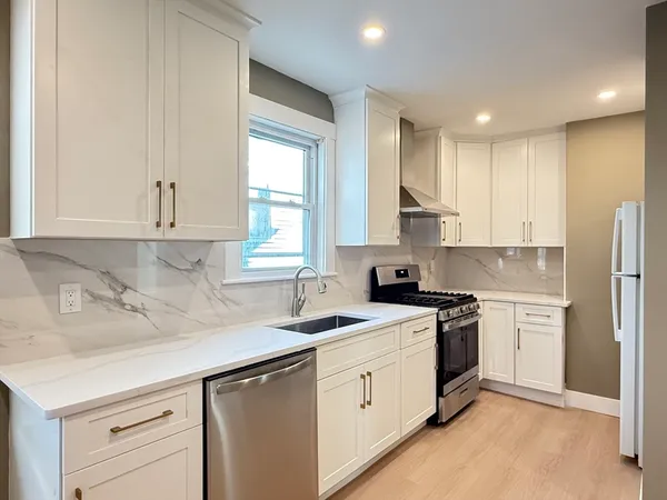 a kitchen with stainless steel appliances granite countertop a sink stove and refrigerator