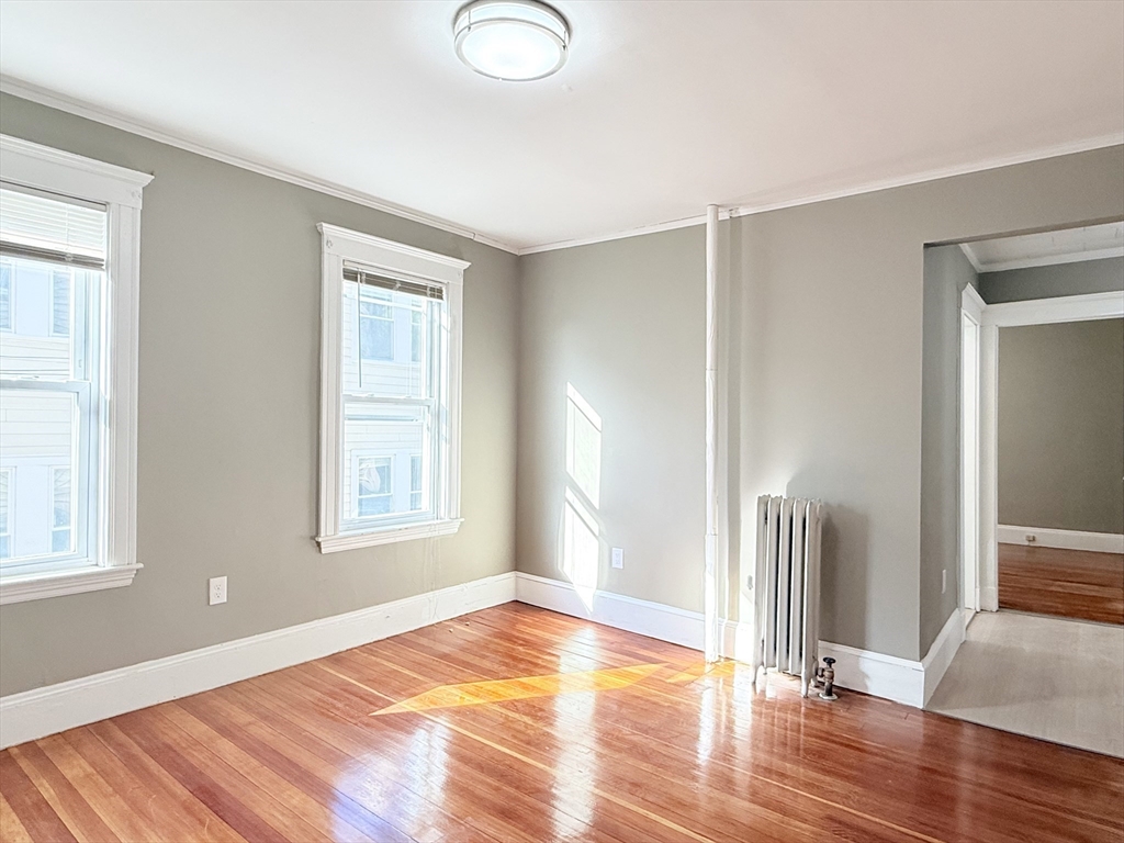 21 High Street, Unit 1 Somerville, MA 02144 - Photo 11 of 14 a view of empty room with wooden floor and fan