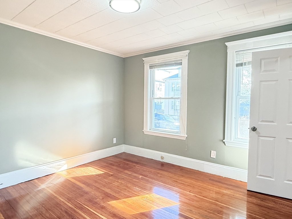 21 High Street, Unit 1 Somerville, MA 02144 - Photo 13 of 14 an empty room with wooden floor and windows
