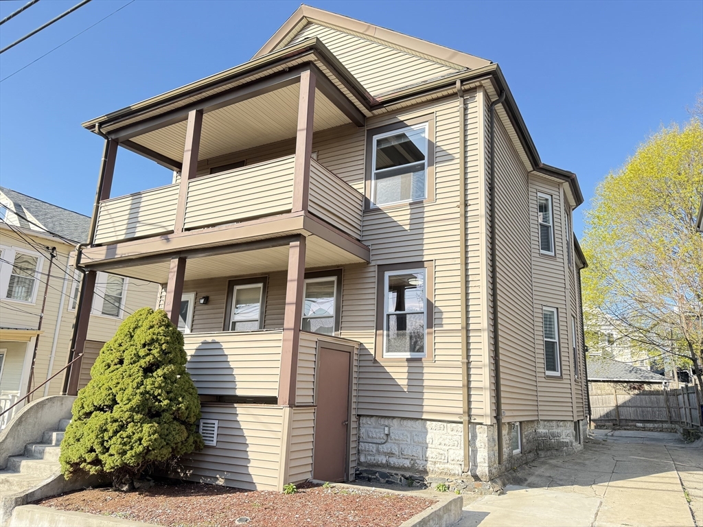 21 High Street, Unit 1 Somerville, MA 02144 - Photo 14 of 14 a yellow and white house with a small yard