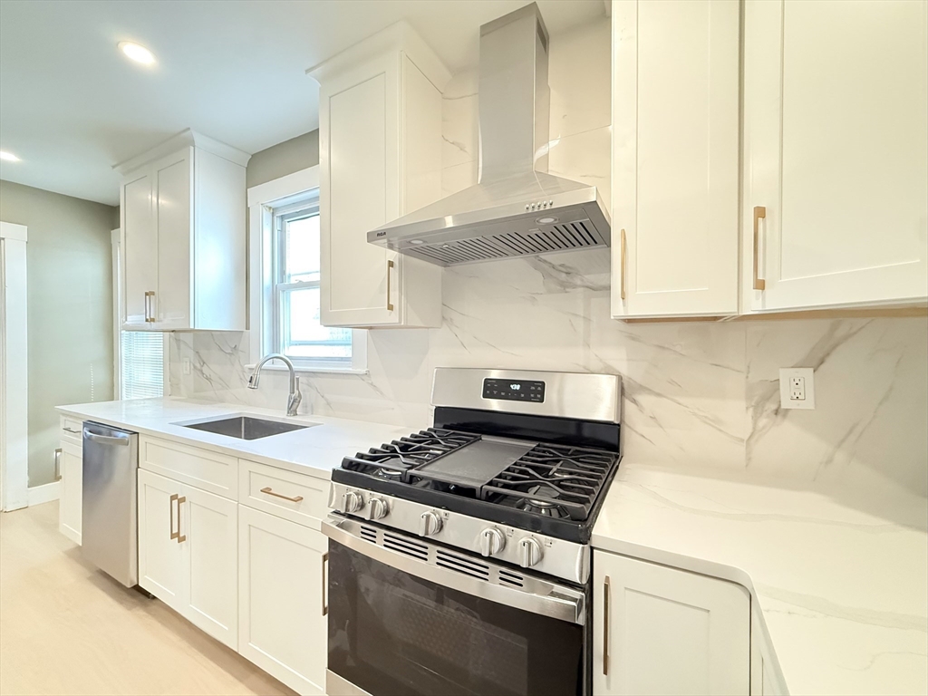 21 High Street, Unit 1 Somerville, MA 02144 - Photo 4 of 14 a kitchen with stainless steel appliances white cabinets and a stove