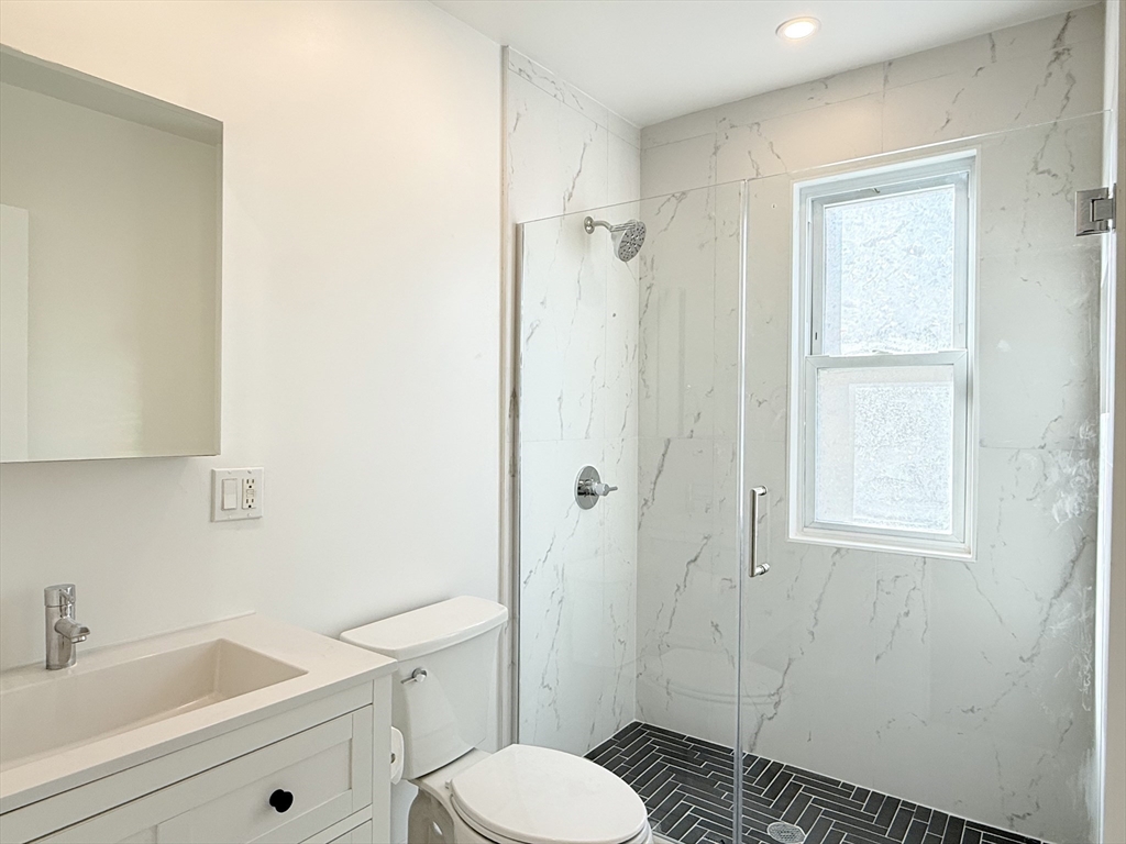 21 High Street, Unit 1 Somerville, MA 02144 - Photo 6 of 14 a bathroom with a sink toilet and shower