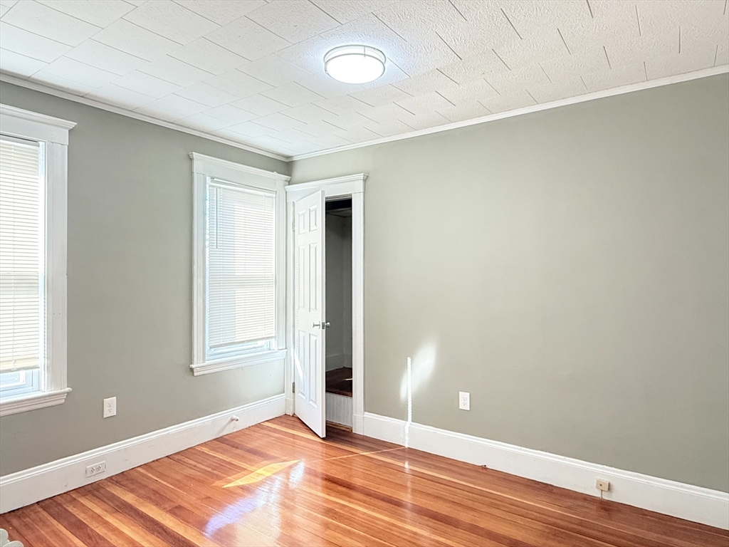 21 High Street, Unit 1 Somerville, MA 02144 - Photo 7 of 14 an empty room with wooden floor and windows