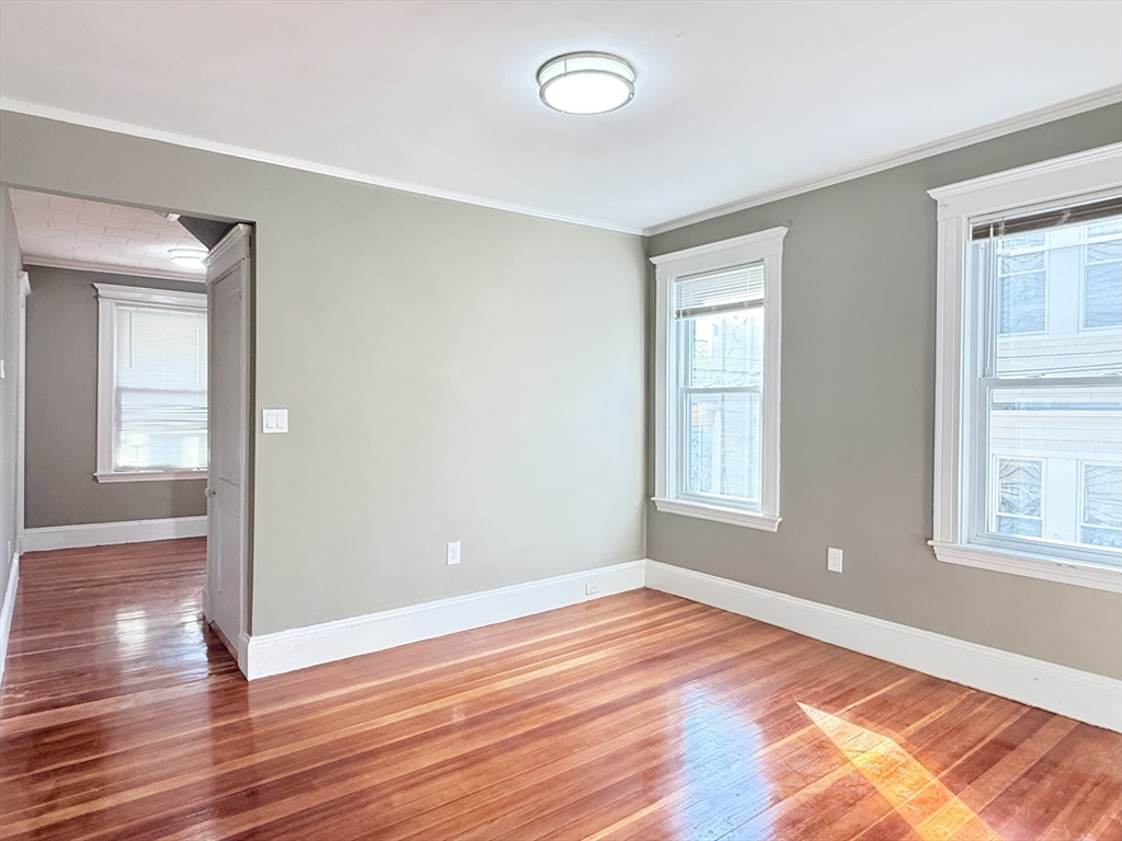 21 High Street, Unit 1 Somerville, MA 02144 - Photo 10 of 14 a view of empty room with wooden floor and fan