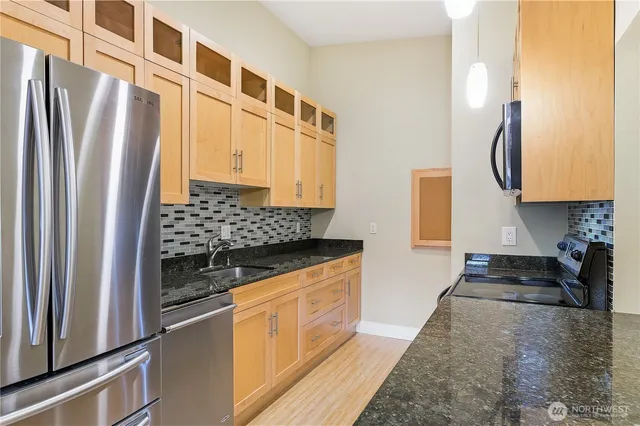 a kitchen with stainless steel appliances granite countertop a refrigerator and a stove