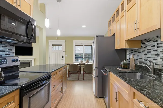 a kitchen with stainless steel appliances granite countertop a sink stove and refrigerator