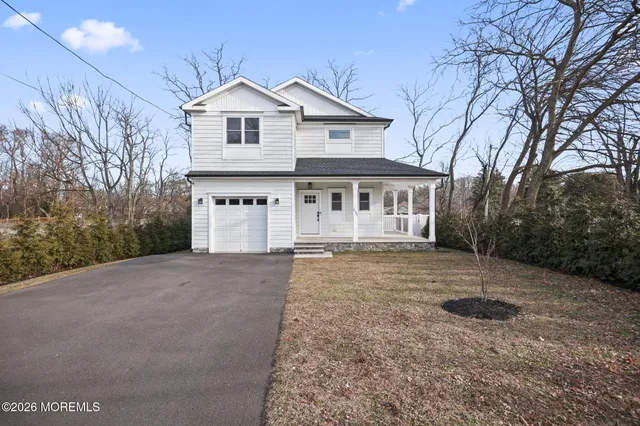 a view of a house with a yard and large tree