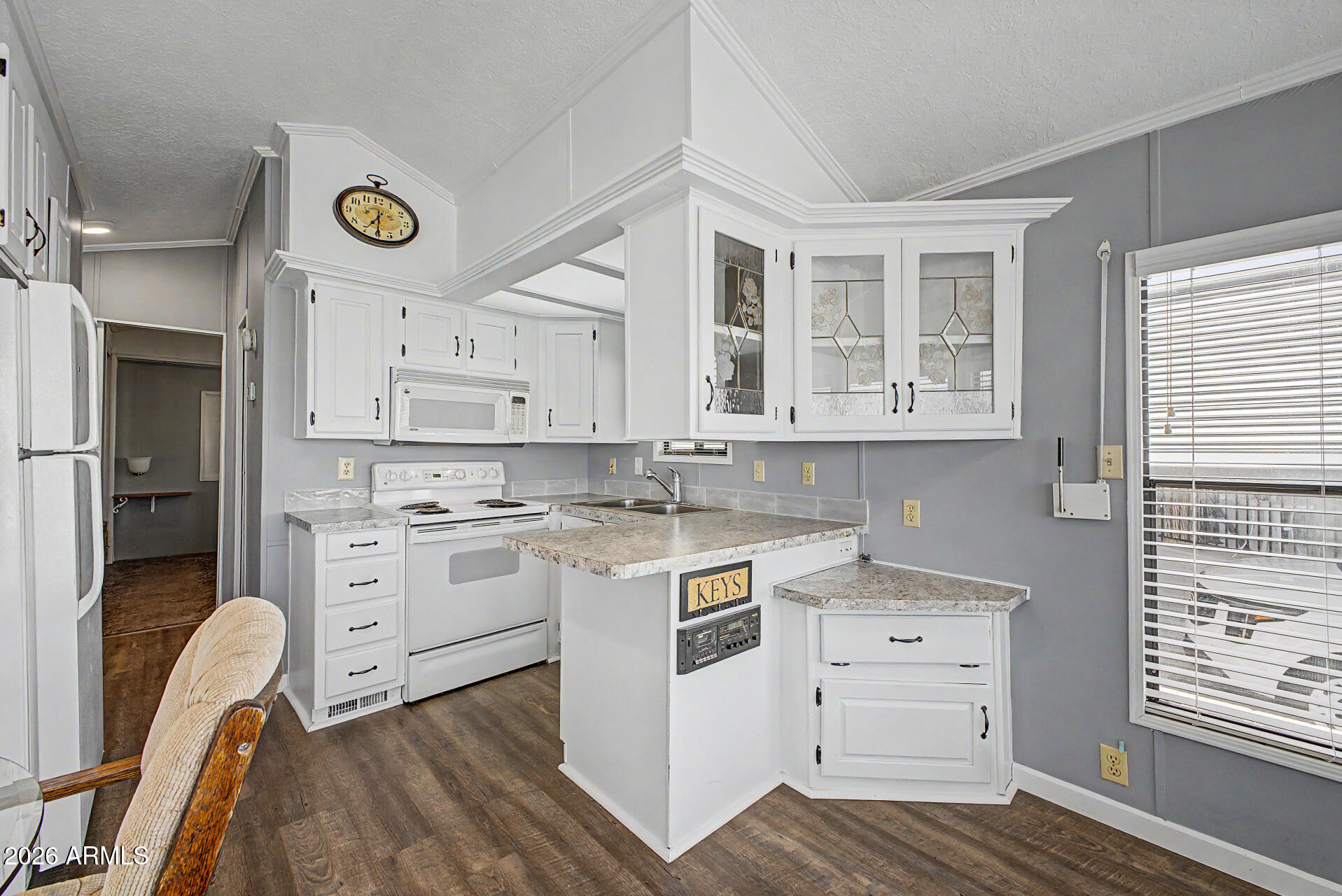 7750 East Broadway Road, Unit 560 Mesa, AZ 85208 - Photo 7 of 18 a kitchen with a stove window and cabinets
