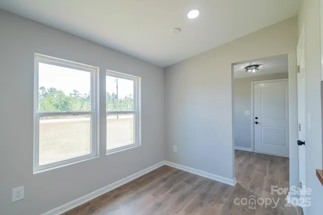 a kitchen with stainless steel appliances granite countertop a sink a stove and microwave with wooden floor
