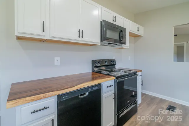 a kitchen with stainless steel appliances granite countertop a sink stove and cabinets