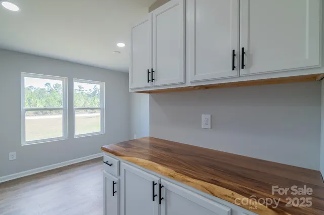 a kitchen with stainless steel appliances granite countertop a sink dishwasher a stove and a refrigerator with wooden floor