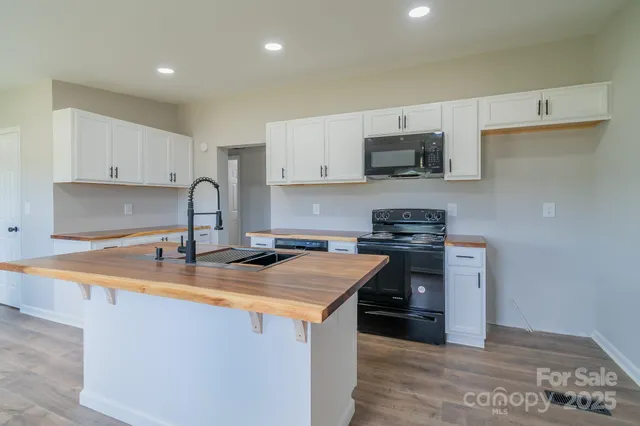 a kitchen with stainless steel appliances granite countertop a sink stove and microwave