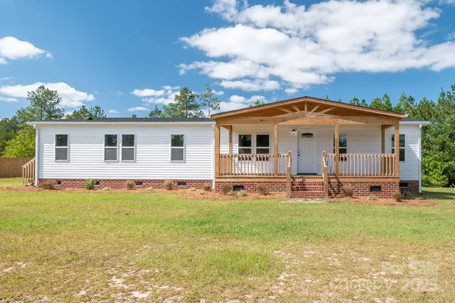 a view of a house with a yard and sitting area