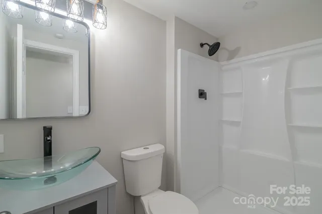 an empty room with wooden floor cabinet and windows