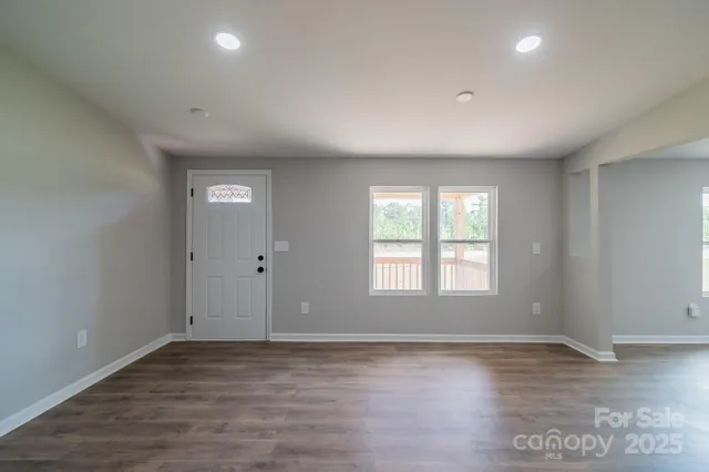 wooden floor in an empty room with a ceiling fan